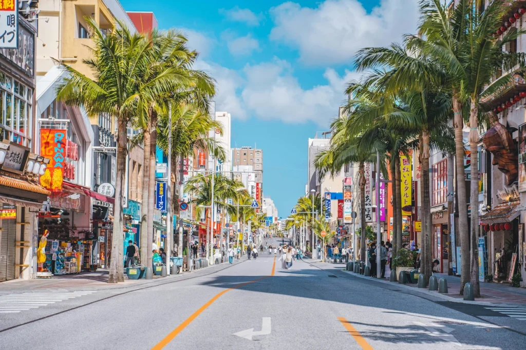 Palm trees lining Kokusai Dori street under a blue sky in Okinawa