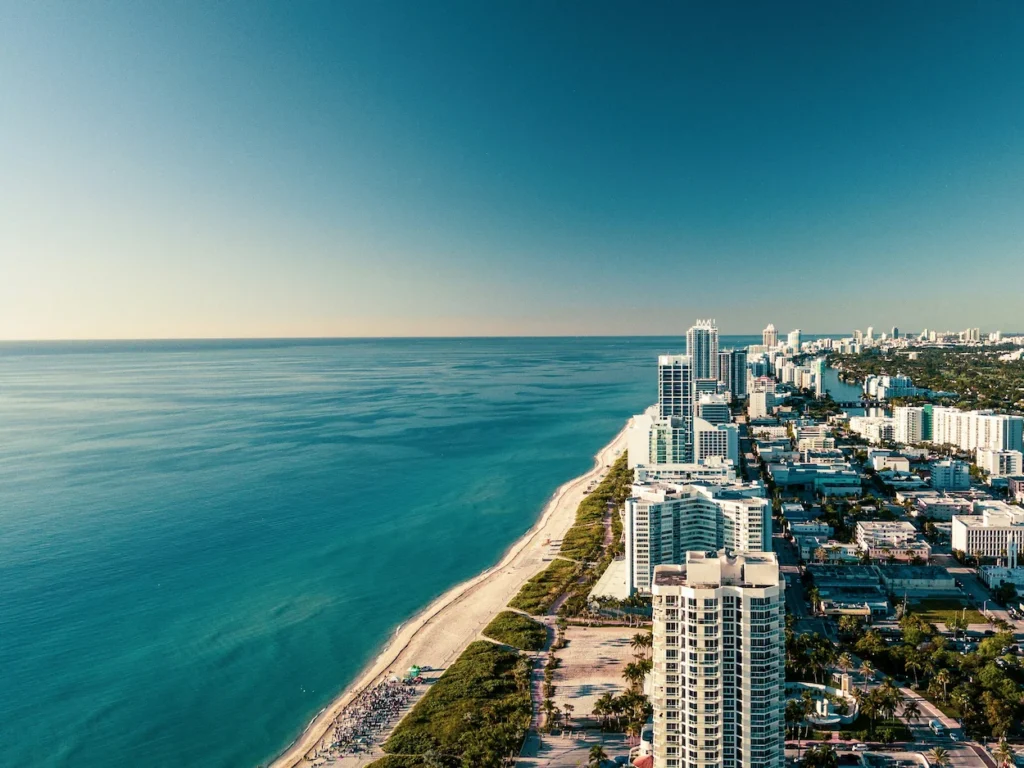 An aerial drone perspective of the sandy Miami Beach coastline meeting the Atlantic Ocean