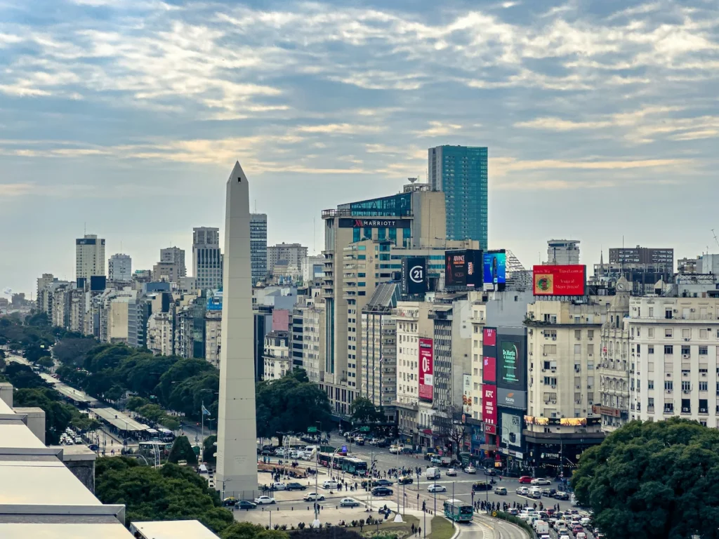 Obelisco monument stands tall next to busy avenues and high-rise buildings in Buenos Aires