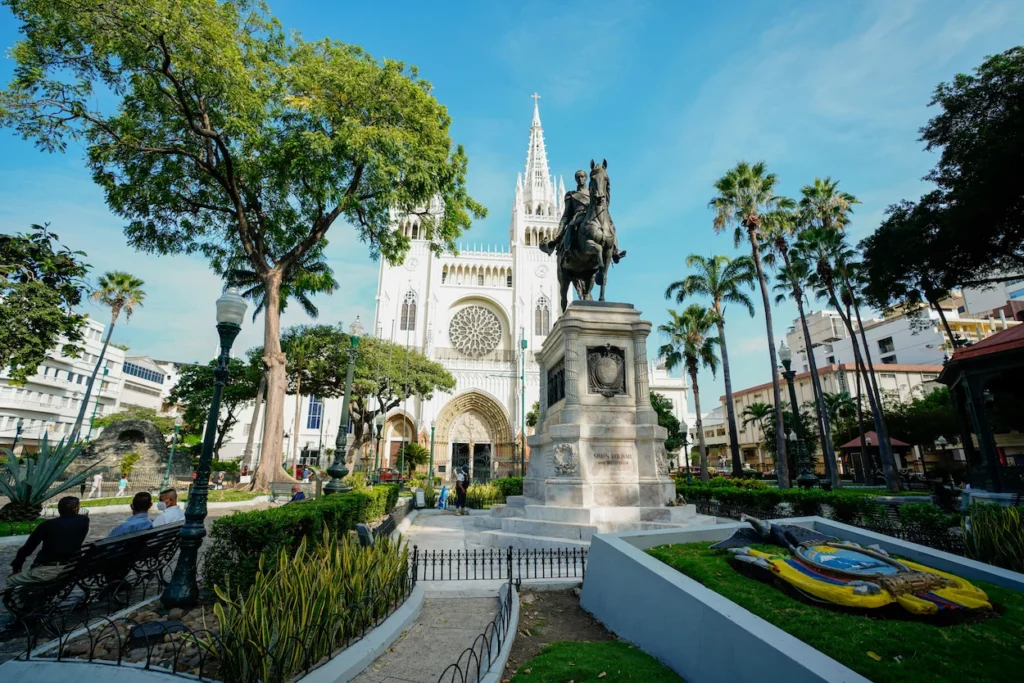 Simon Bolivar equestrian statue in front of the white gothic Cathedral of Guayaquil