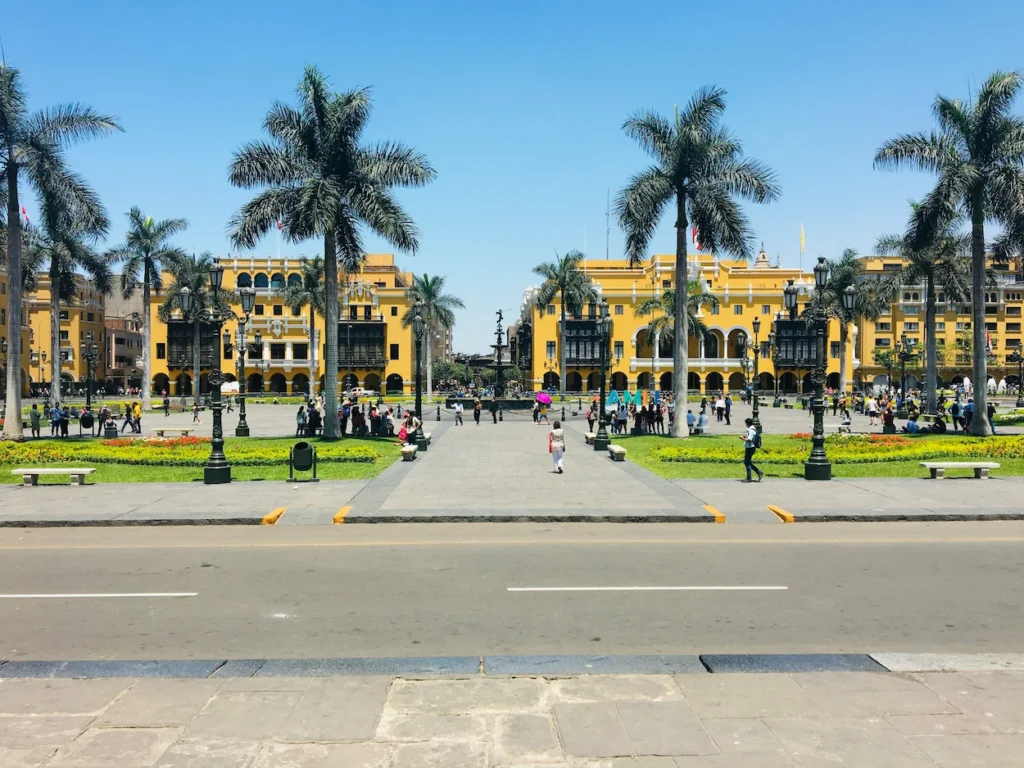 Plaza Mayor in Lima with bright yellow buildings and tall palm trees