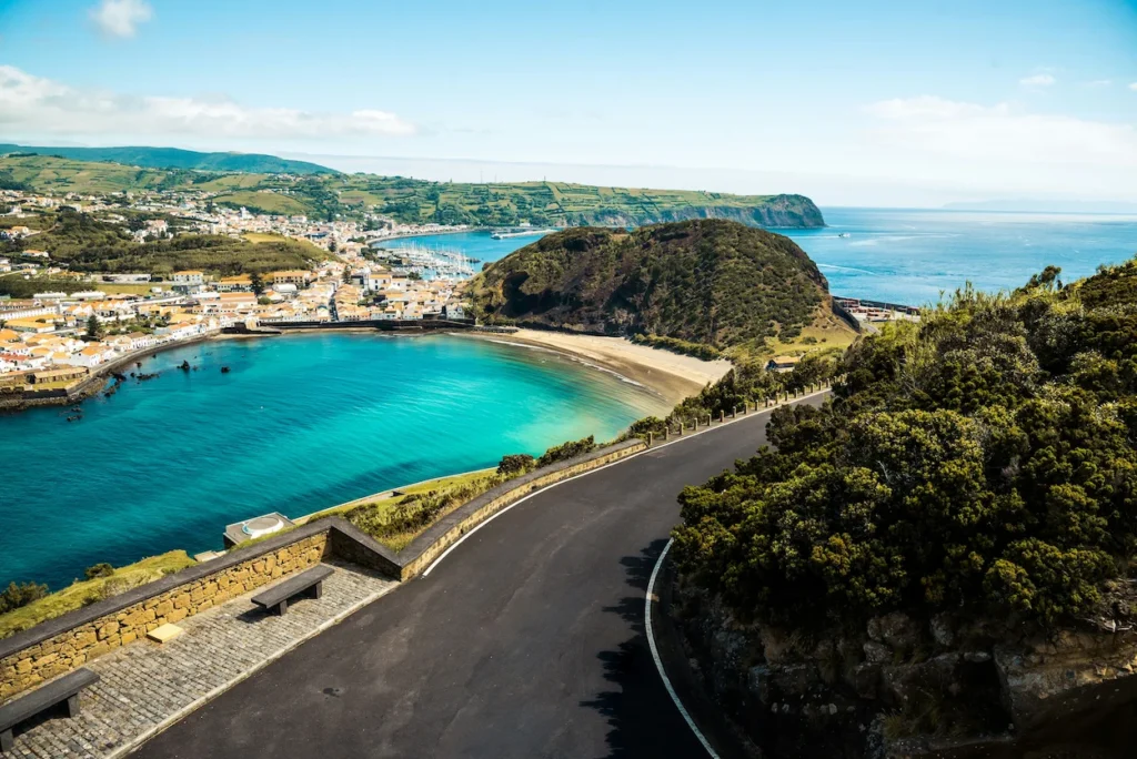 High-angle view of a curved road overlooking Porto Pim bay and the town of Horta