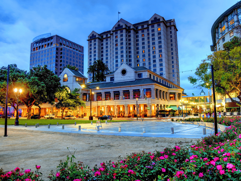 A street view of downtown San Jose at night, showing beautiful old architecture and flower gardens