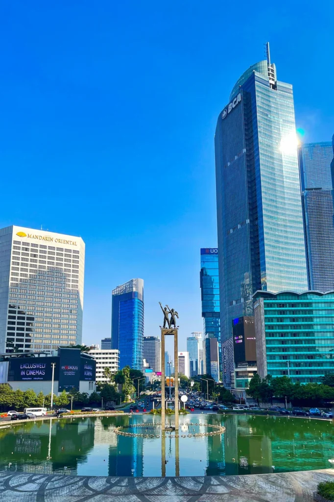 Selamat Datang Monument inside the Bundaran HI fountain surrounded by skyscrapers
