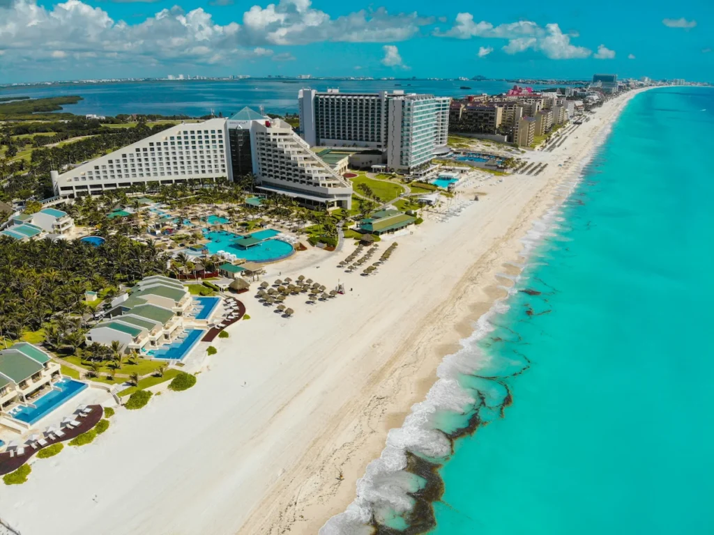 Aerial view of luxury beachfront resorts lining the turquoise sea in the Hotel Zone of Cancún, Mexico