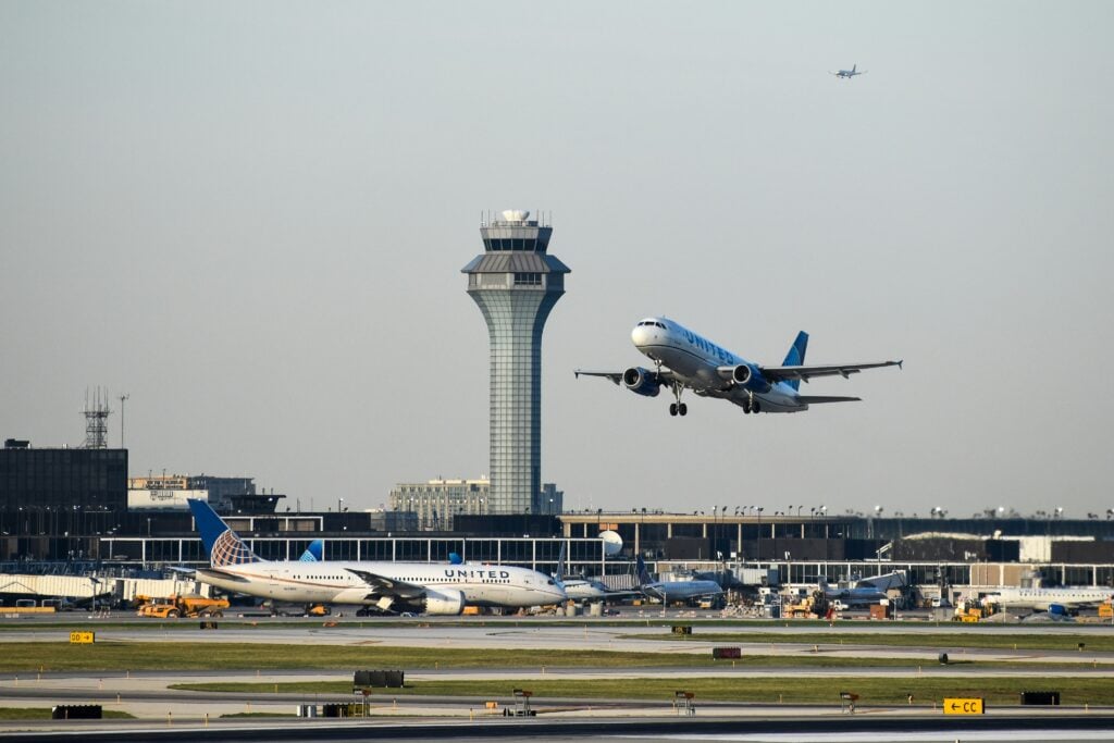 United Airlines plane taking off past the Chicago O'Hare control tower