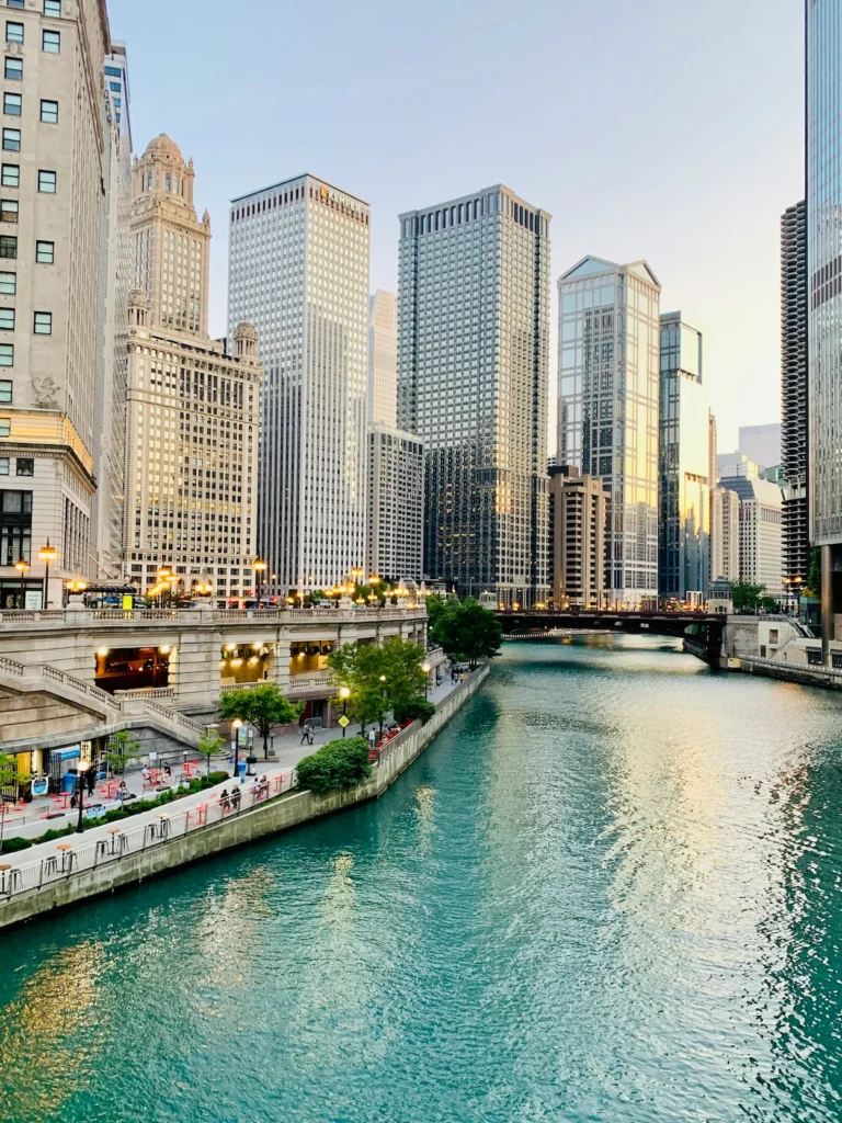 Chicago Riverwalk path running alongside the Chicago River with the downtown Loop skyline buildings
