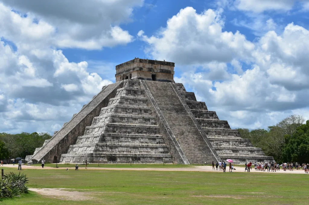 The Mayan pyramid of El Castillo at Chichen Itza under a blue sky with white clouds