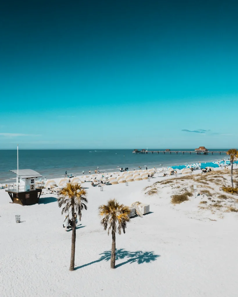 High-angle view of Clearwater Beach with white sand, palm trees, and Pier 60