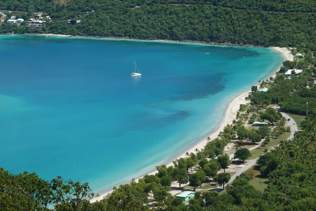 An aerial view of the turquoise water and white sand crescent at Magens Bay