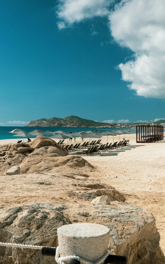 Lounge chairs and umbrellas on a sandy beach in Cabo San Lucas