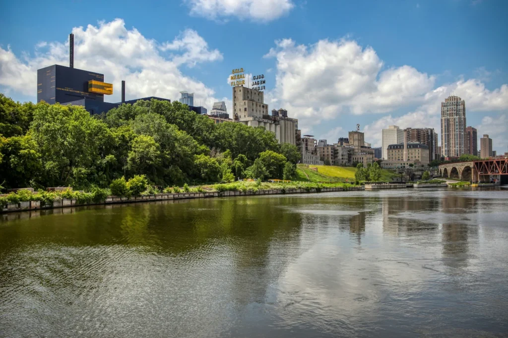 Mississippi River flowing past the historic Mill District buildings and stone arch bridge ruins in Minneapolis