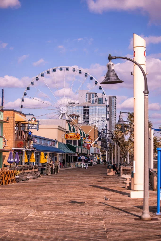 Wooden boardwalk leading toward the large SkyWheel ferris wheel in Myrtle Beach, South Carolina