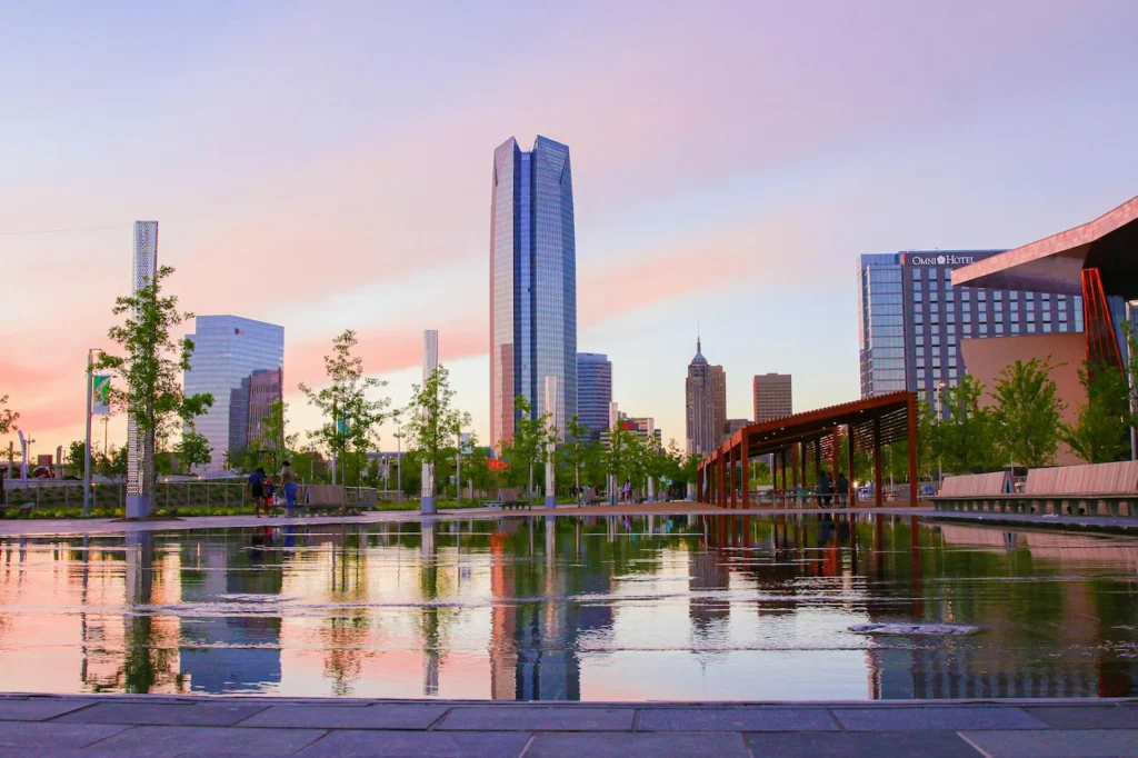 Oklahoma City skyline and Devon Tower reflecting in the Scissortail Park water feature at sunset