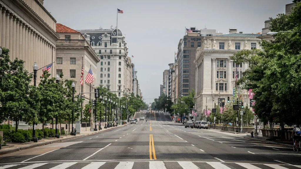An empty Pennsylvania Avenue lined with historic government buildings and American flags