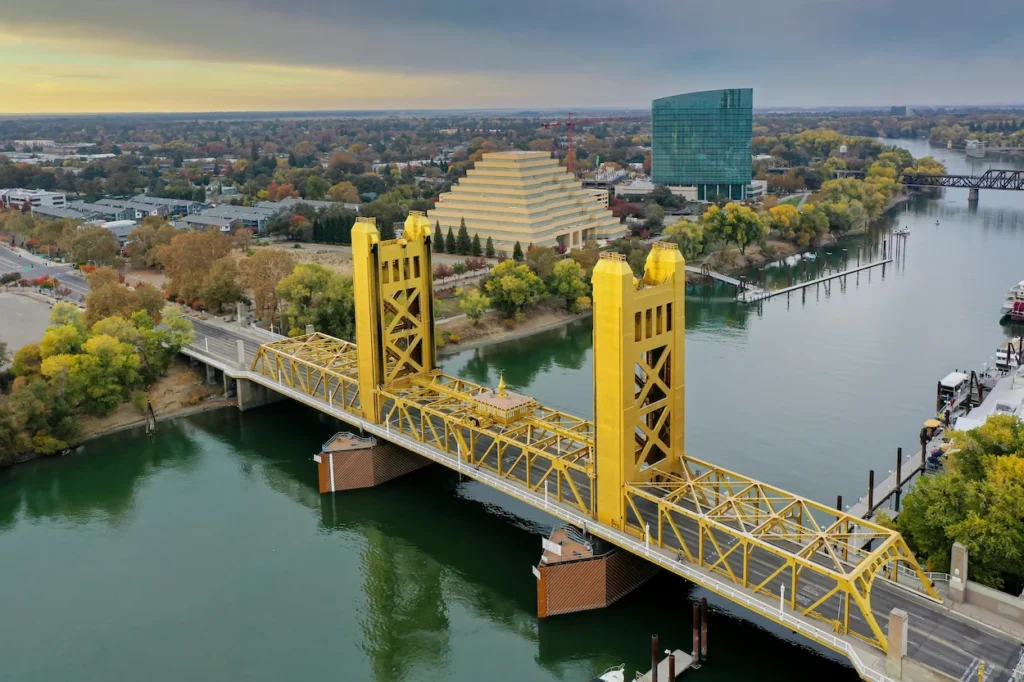 The yellow Tower Bridge over the Sacramento River with the Ziggurat building in the background