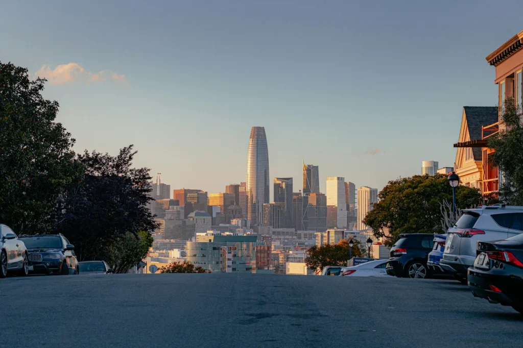 A San Francisco hill street looking down toward downtown skyscrapers and the prominent Salesforce Tower