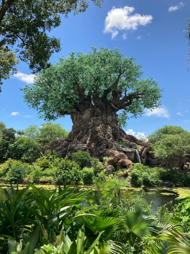 The Tree of Life structure surrounded by lush green foliage and water at Disney's Animal Kingdom