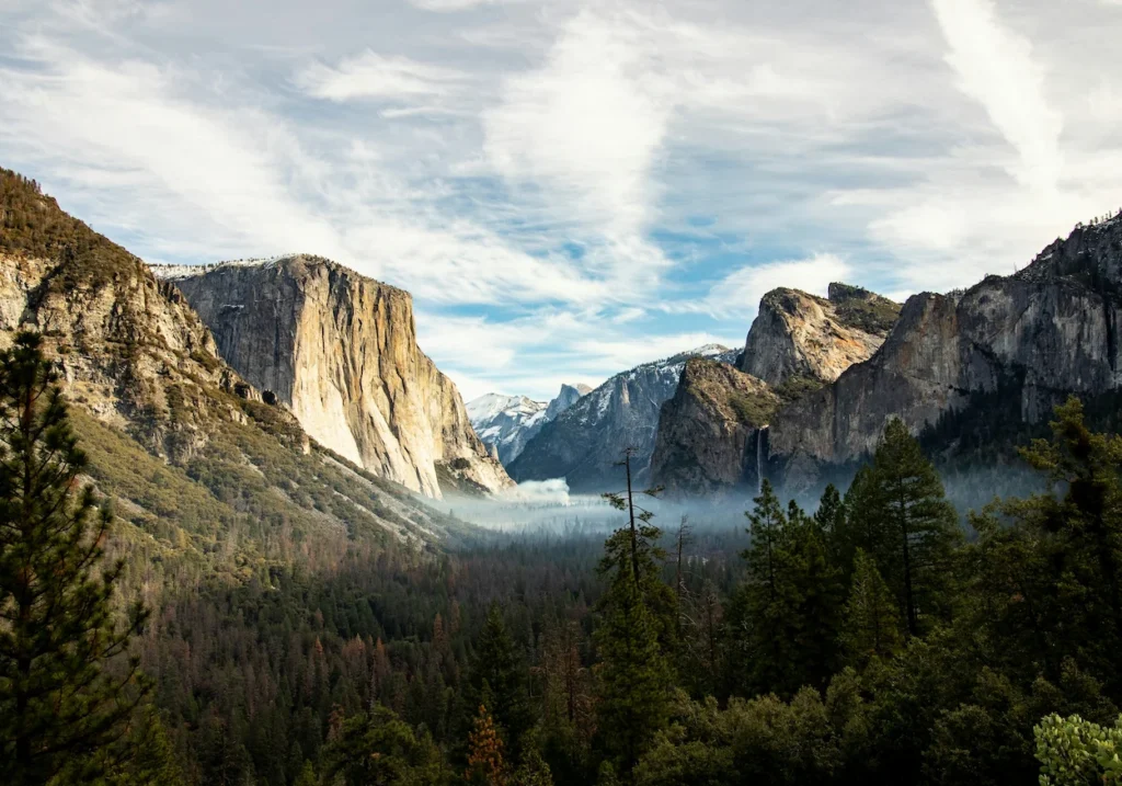 Yosemite Valley view with El Capitan, Bridalveil Fall, and Half Dome framed by pine trees