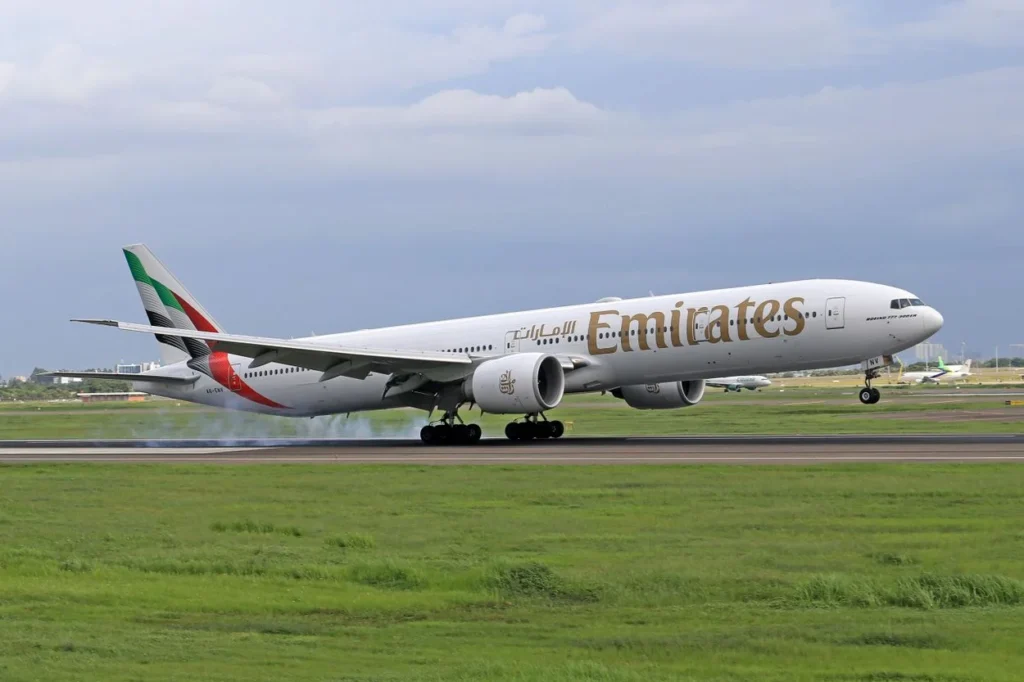 An Emirates Boeing 777 passenger airplane landing on a runway