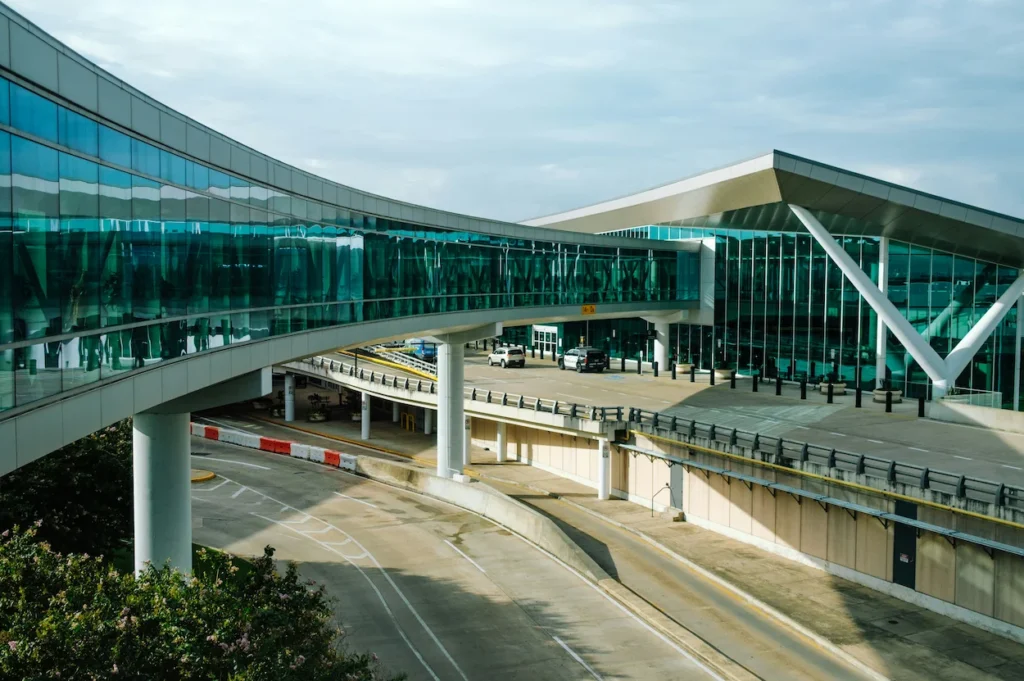 Glass skybridge walkway leading into the modern Houston Hobby Airport terminal building