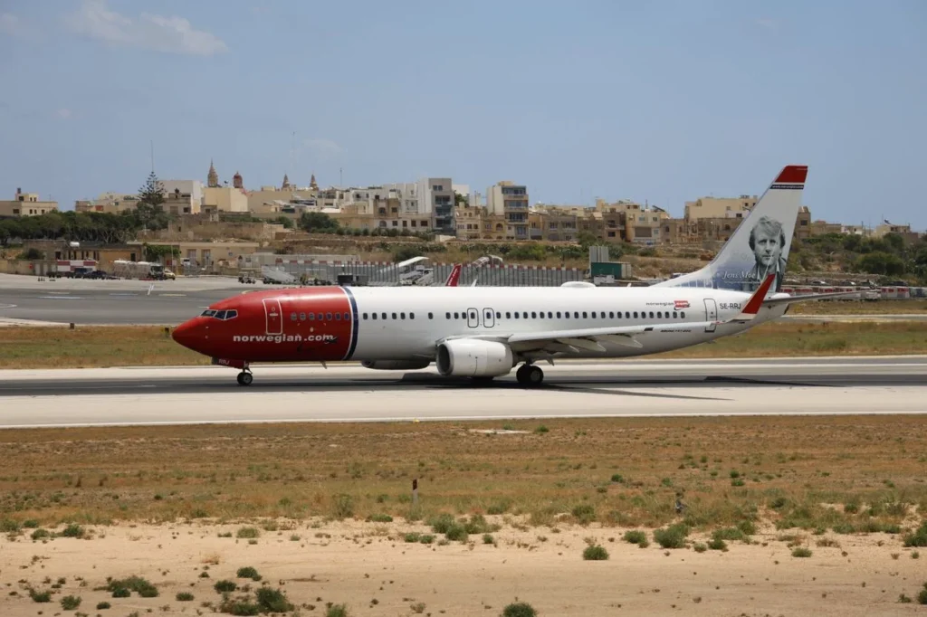 A Norwegian Air Shuttle Boeing 737-800 airplane taxiing on an airport runway