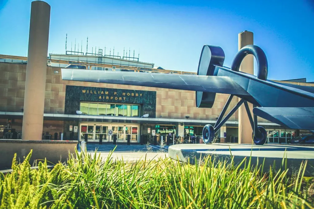 A large blue airplane sculpture outside the William P. Hobby Airport entrance in Houston, Texas