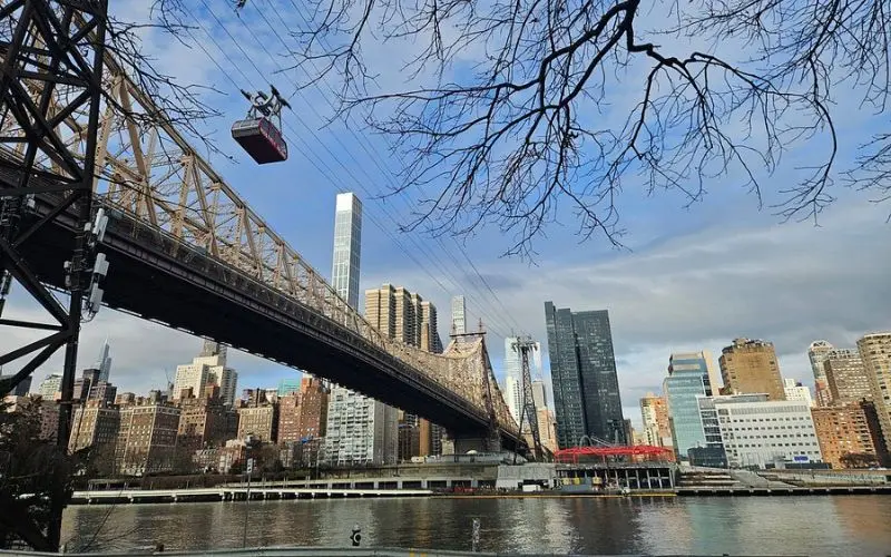 Roosevelt Island Tramway passing over the East River with city views.