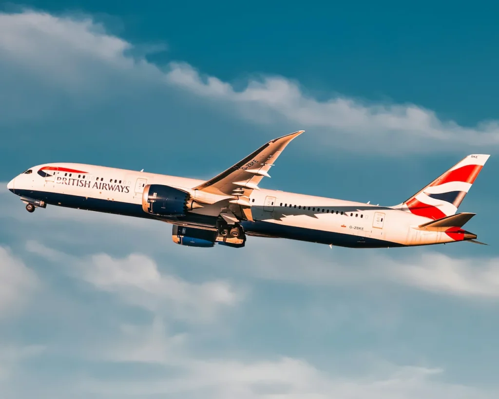 British Airways Boeing 787-9 Dreamliner passenger airplane climbing post-takeoff with landing gear retracting