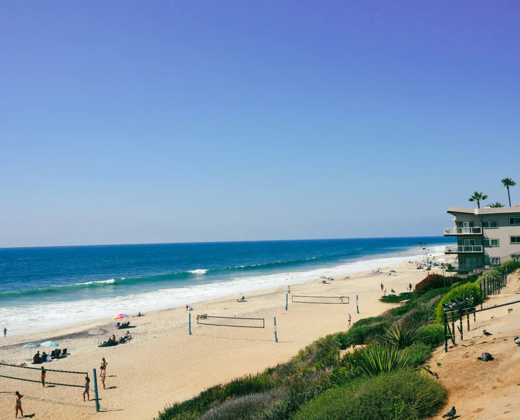 An elevated view of sandy Carlsbad State Beach featuring beachfront volleyball nets