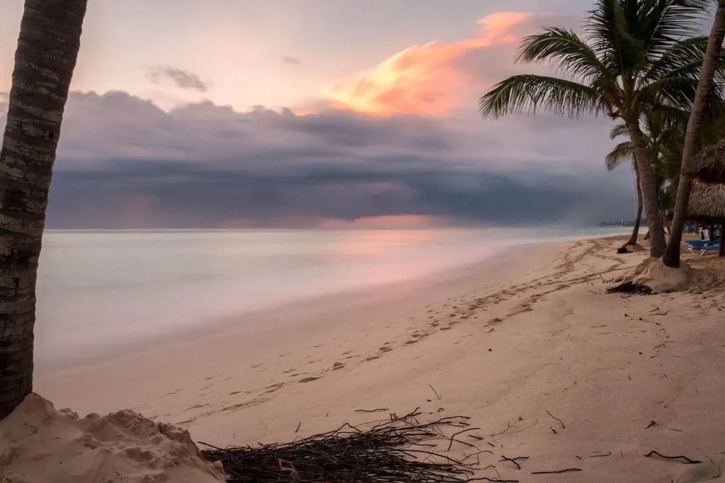 Sunrise over a palm tree lined beach with dramatic clouds in Punta Cana, Dominican Republic