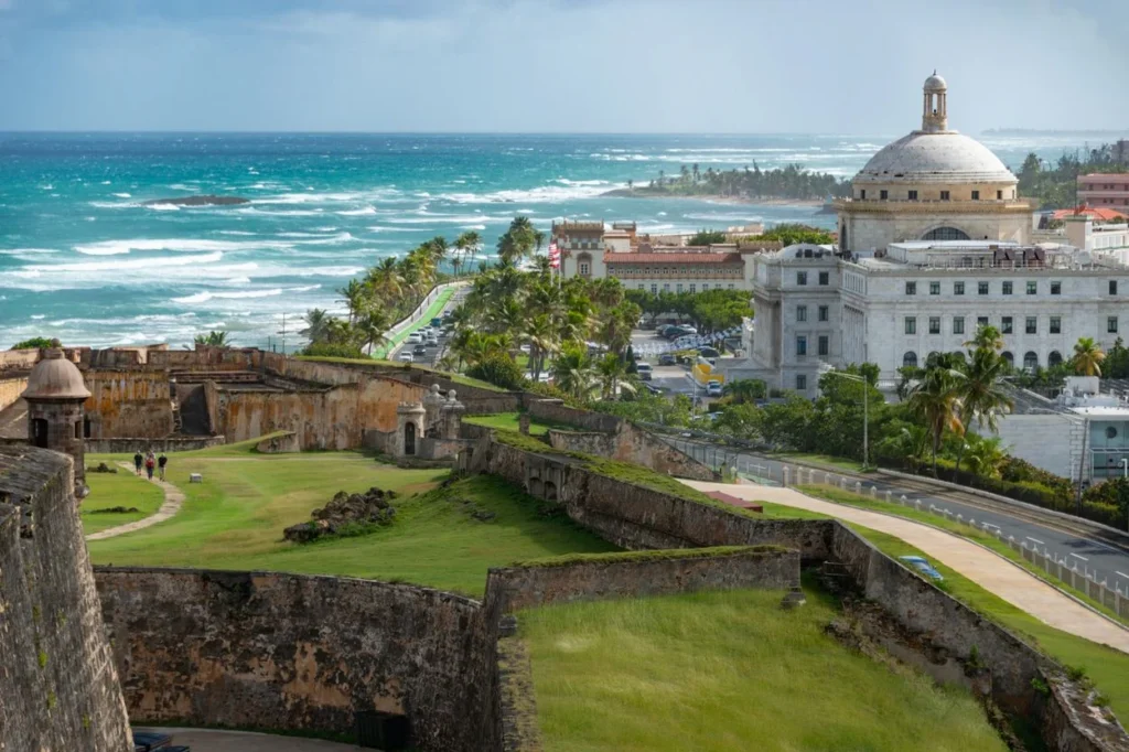 View from an old stone fortress looking toward the white dome of the Puerto Rico Capitol building by the ocean