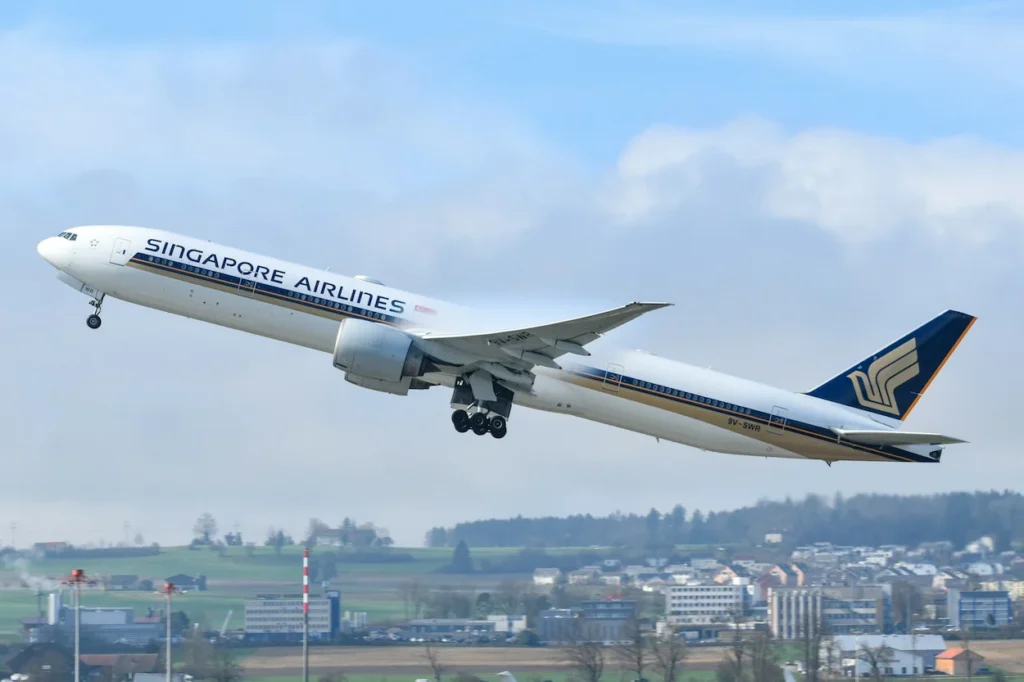 A Singapore Airlines Boeing 777 climbing steeply into the sky immediately after takeoff