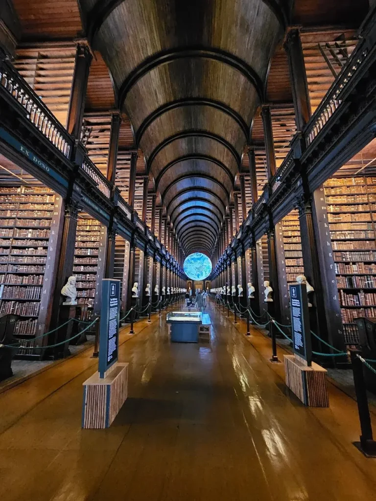 The Long Room of Trinity College Library in Dublin with rows of old books.