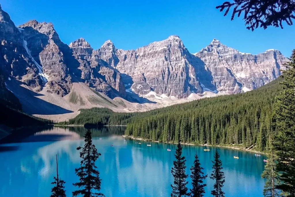 Snow-capped mountains reflect in the turquoise waters of Moraine Lake in Banff National Park, Canada.