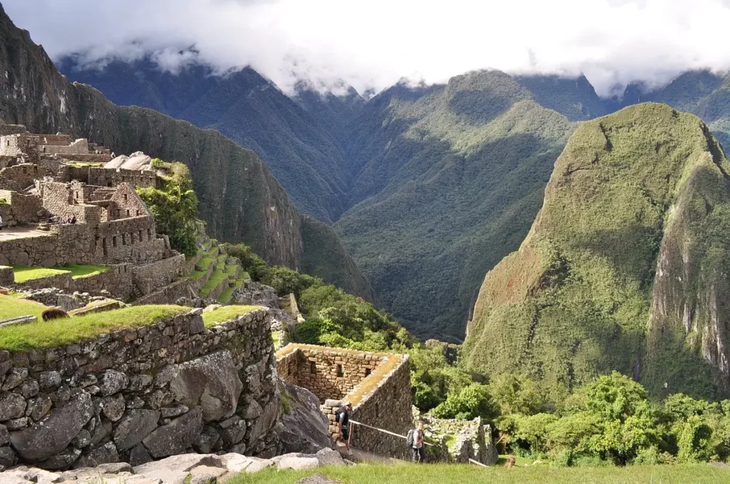 Stone terraces and ruins of Machu Picchu overlook a deep green valley in Peru.