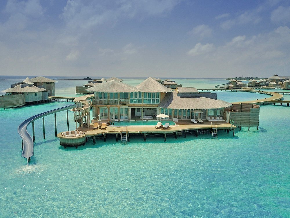 Soneva Jani overwater villa with private pool, deck, and slide into the turquoise lagoon.