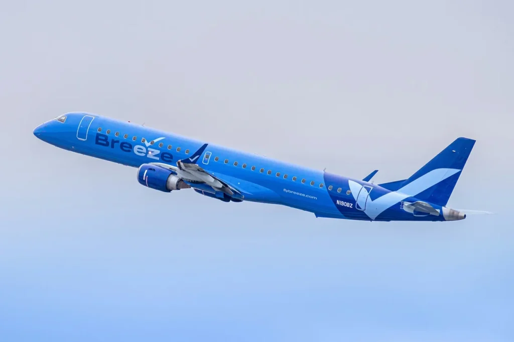 Breeze Airways Embraer E190 passenger jet with registration N190BZ climbing into the sky after takeoff