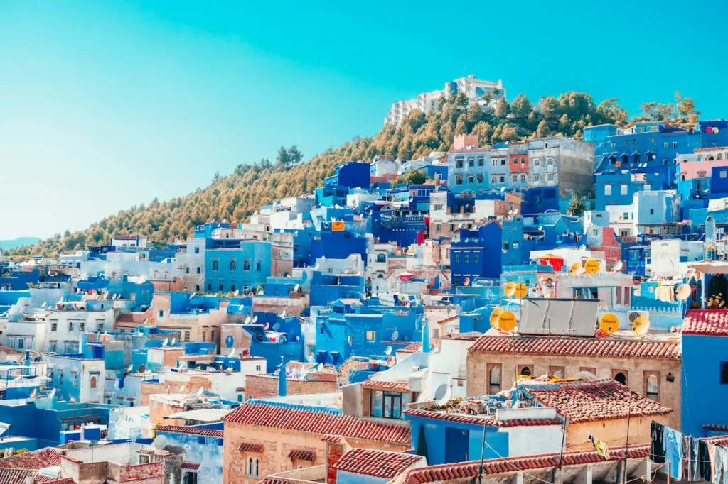 Hillside view of the blue-painted houses and buildings of Chefchaouen, Morocco under a clear sky