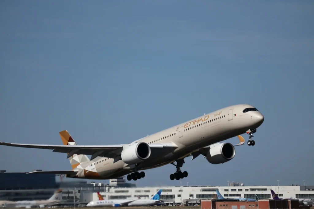 An Etihad Airways Airbus A350-1000 climbing steeply into the sky immediately after takeoff