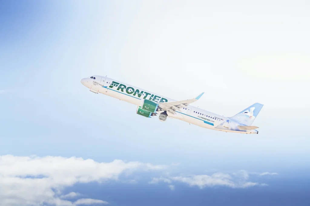 Frontier Airlines Airbus A321neo passenger airplane climbing steeply into a bright blue sky
