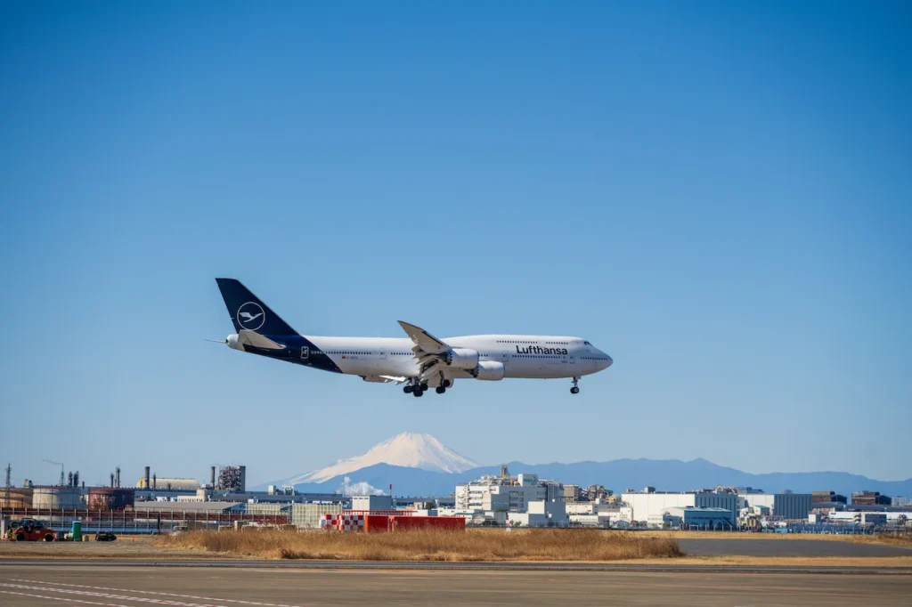 Lufthansa Boeing 747 passenger airplane approaching the runway with a snow-capped Mount Fuji in the background