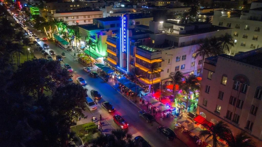 Aerial night view of Ocean Drive traffic and the neon-lit Breakwater Hotel in Miami Beach