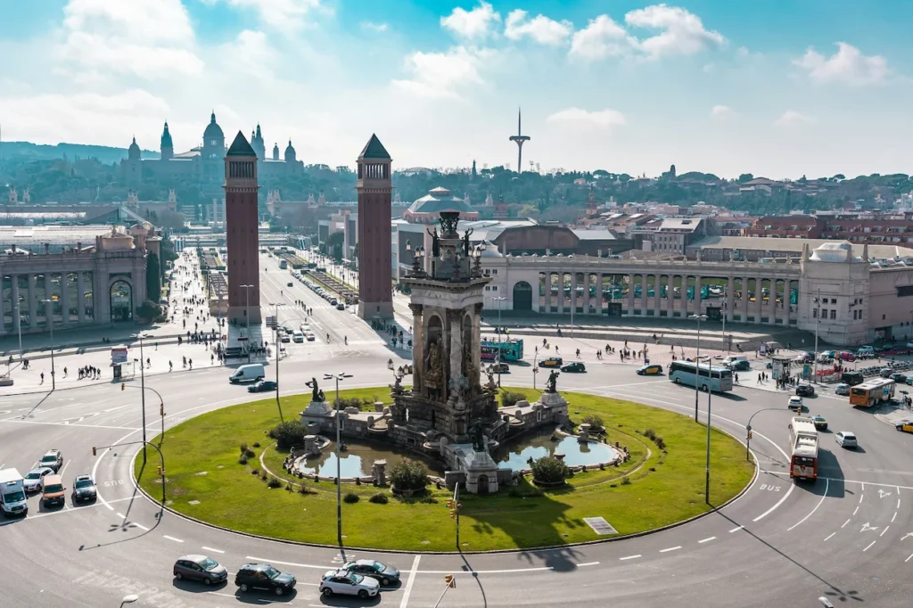 Placa d'Espanya traffic roundabout, central fountain, and Venetian Towers in Barcelona, Spain