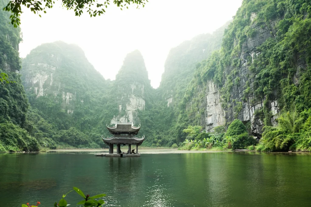 Vu Lam Royal Pavilion temple surrounded by karst mountains and water in Ninh Binh, Vietnam