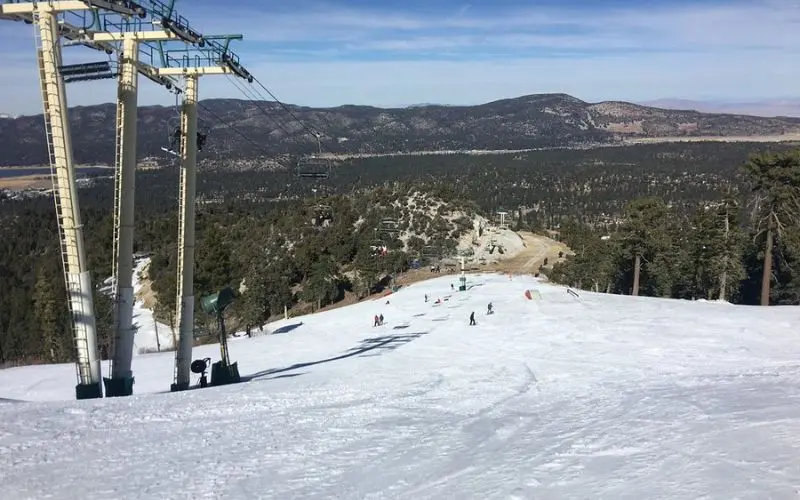 Skiers ride down the snowy slopes at Bear Mountain Ski Resort.
