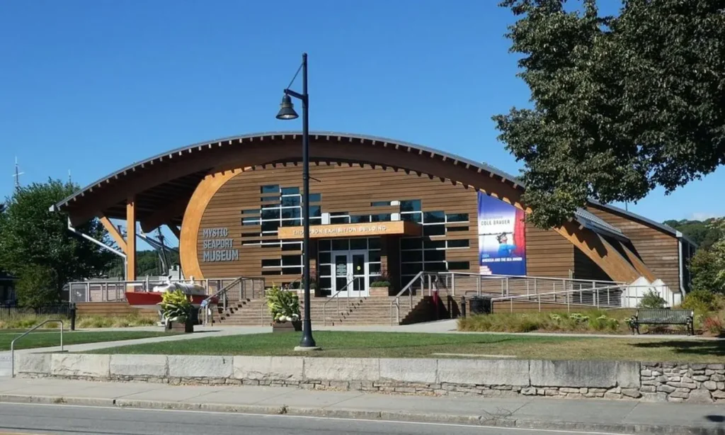 Modern wooden building with arched roof and large windows at Mystic Seaport Museum.