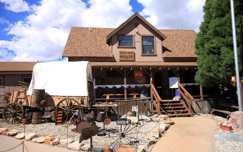 A rustic building and wagon sit outside the Big Bear Historical Museum.
