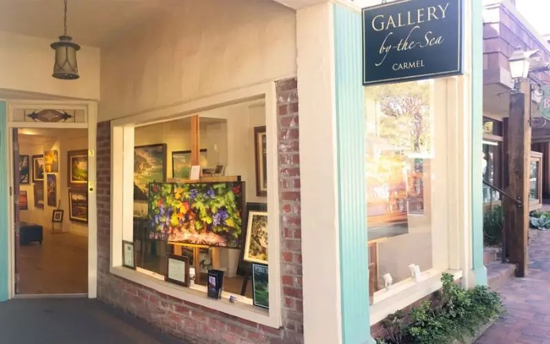 Entrance to a gallery displaying colorful artwork at Carmel's Art Galleries.