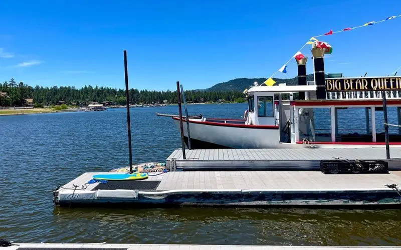 The Big Bear Queen boat is docked on the lake.